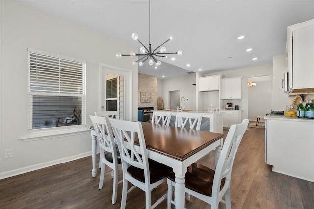 dining room featuring sink, an inviting chandelier, and dark hardwood / wood-style floors