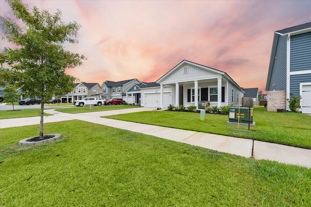 view of front of home with a yard, a porch, and a garage