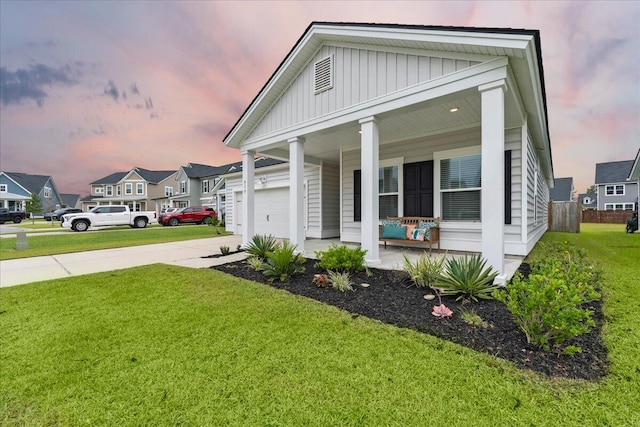 view of front facade with a garage, a lawn, and a porch