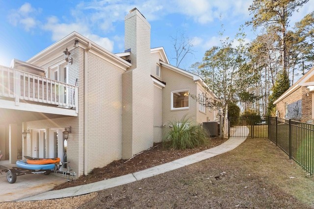 view of side of home featuring central air condition unit and a balcony