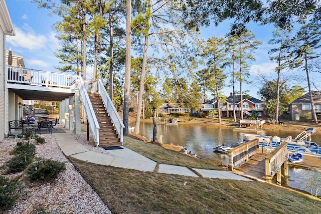 dock area featuring a patio area, a yard, and a deck with water view