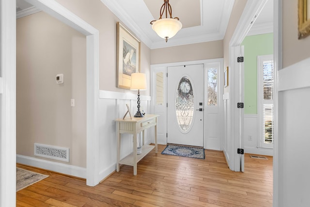 foyer featuring crown molding and light hardwood / wood-style flooring