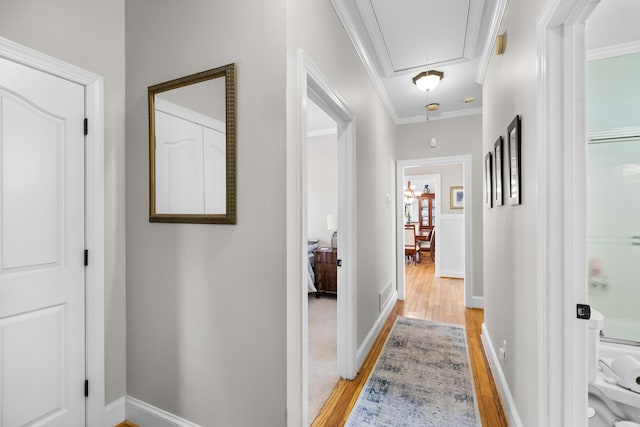 hallway featuring light hardwood / wood-style floors and ornamental molding