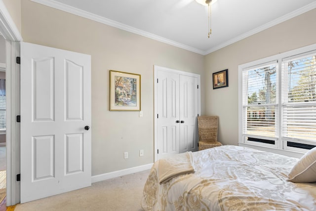 carpeted bedroom featuring a closet, crown molding, and ceiling fan