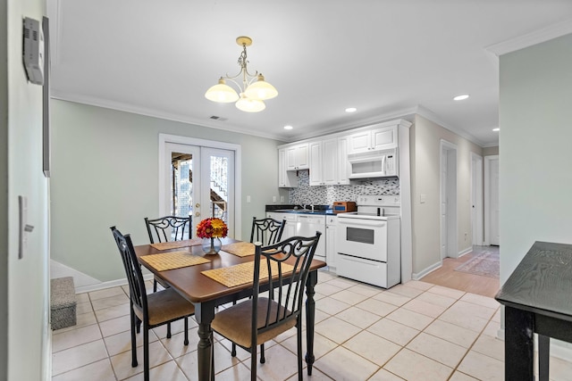 dining space featuring a chandelier, light tile patterned floors, ornamental molding, and french doors