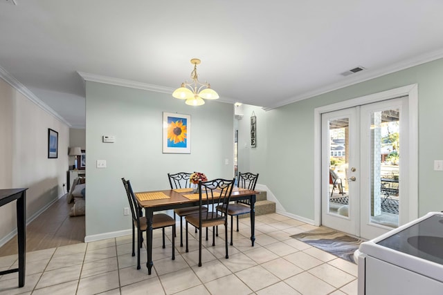 tiled dining room with a notable chandelier, ornamental molding, and french doors