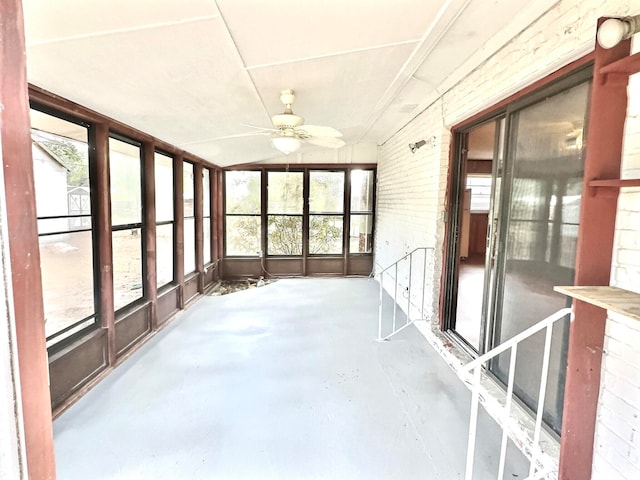 unfurnished sunroom with ceiling fan