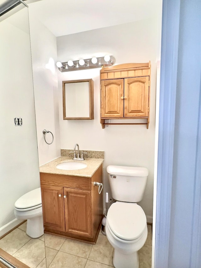 bathroom featuring tile patterned flooring, vanity, and toilet