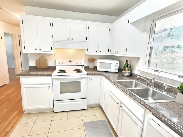 kitchen featuring white cabinetry, sink, white appliances, and light tile patterned floors