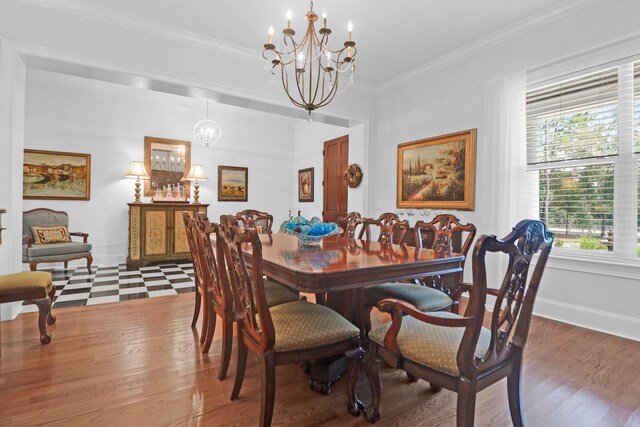 dining area with wood-type flooring, ornamental molding, and a chandelier