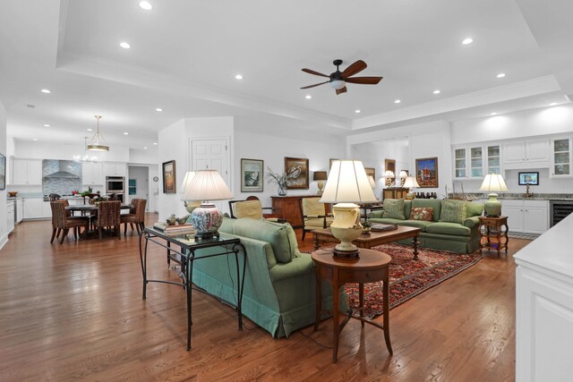 living room featuring crown molding, a tray ceiling, dark hardwood / wood-style floors, and wine cooler