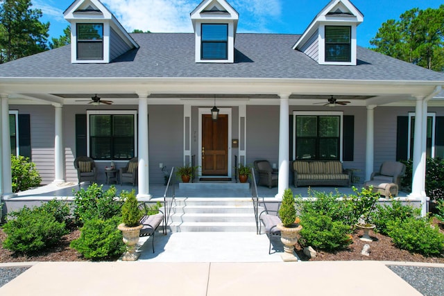 new england style home featuring ceiling fan, a porch, and roof with shingles