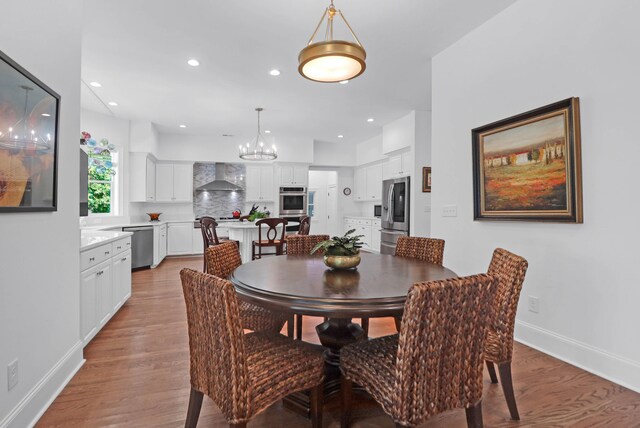 dining room with light hardwood / wood-style floors and a notable chandelier