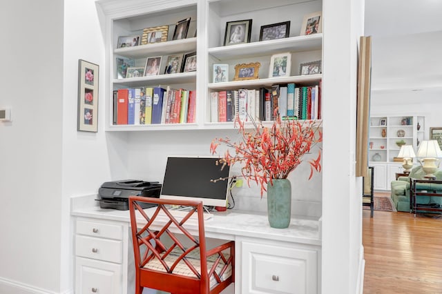 office area with built in desk and light wood-type flooring