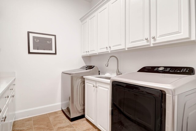 laundry room with cabinets, washer and clothes dryer, and sink