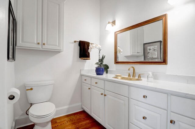 bathroom featuring vanity, hardwood / wood-style flooring, and toilet