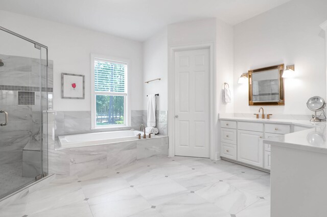 bathroom with vanity and shower with separate bathtub