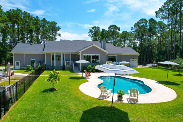 back of house featuring a fenced in pool, a yard, and a patio area