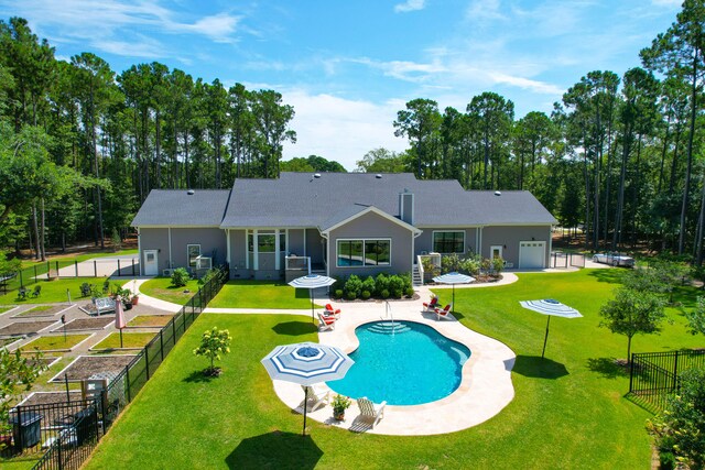 rear view of property with a fenced in pool, a patio, a garage, and a yard