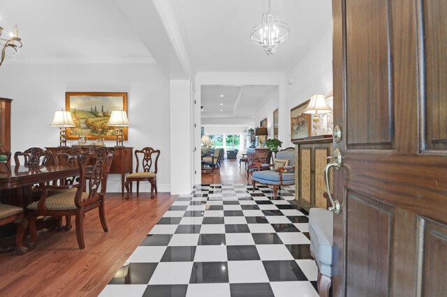 foyer with crown molding and an inviting chandelier