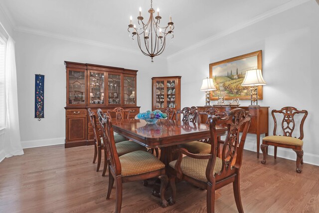 dining room with ornamental molding, hardwood / wood-style floors, and a notable chandelier