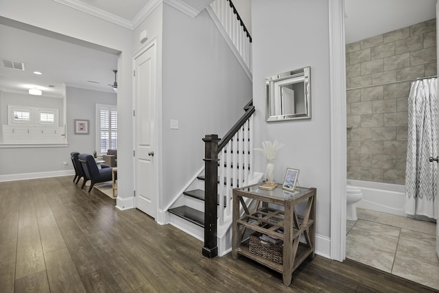 stairs featuring baseboards, visible vents, wood finished floors, and ornamental molding