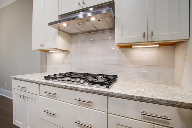 1363 Rivella Dr, Mount Pleasant, SC 29464 - kitchen featuring under cabinet range hood, stainless steel gas stovetop, white cabinetry, decorative backsplash, and baseboards