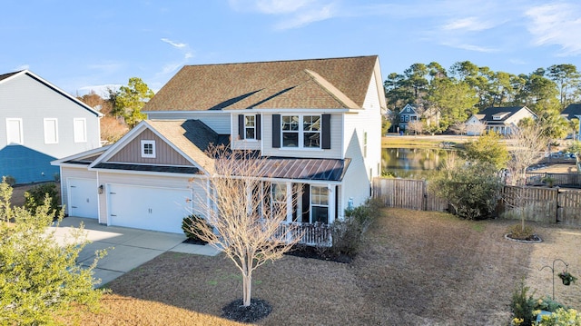 view of front of property featuring a water view, a garage, and covered porch