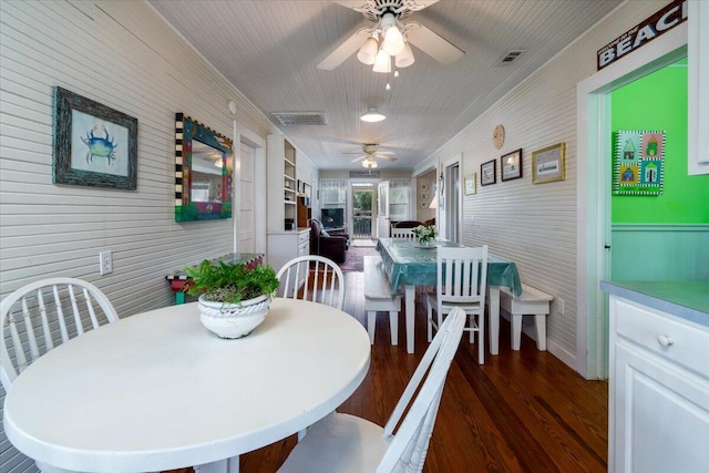 dining space featuring ceiling fan, dark hardwood / wood-style floors, and crown molding