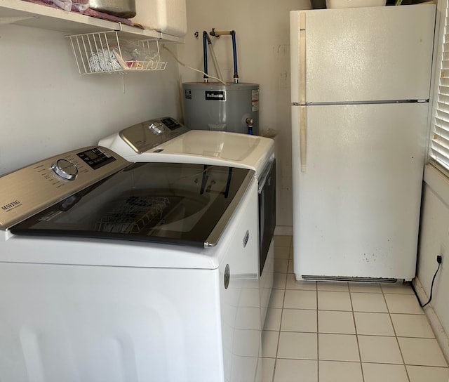 washroom featuring light tile patterned flooring, water heater, and washer and clothes dryer