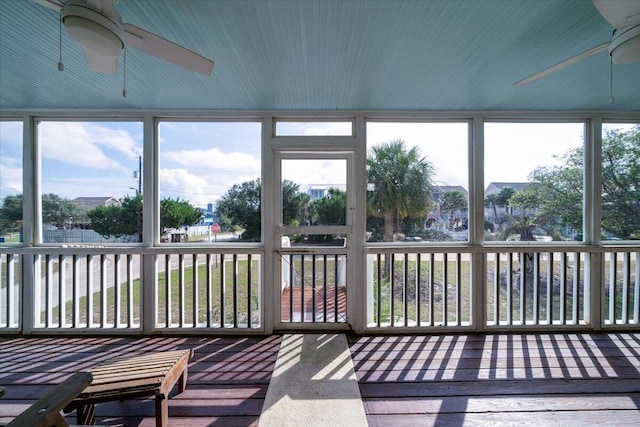 unfurnished sunroom featuring a healthy amount of sunlight and ceiling fan