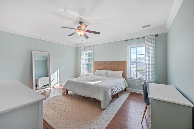 bedroom with ceiling fan, dark hardwood / wood-style floors, and ornamental molding