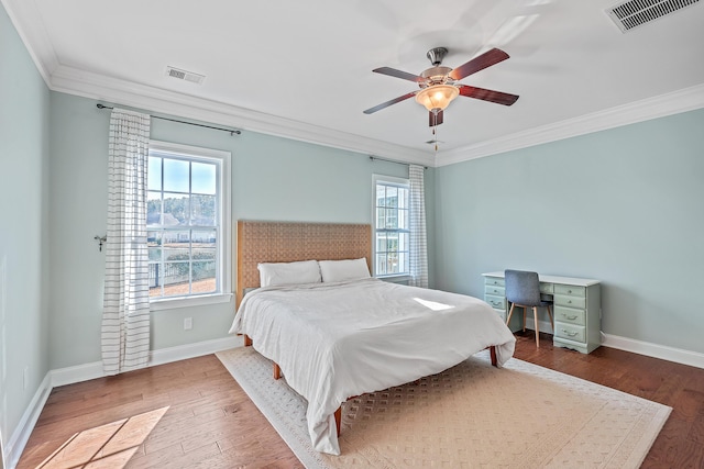 bedroom with ceiling fan, wood-type flooring, and ornamental molding