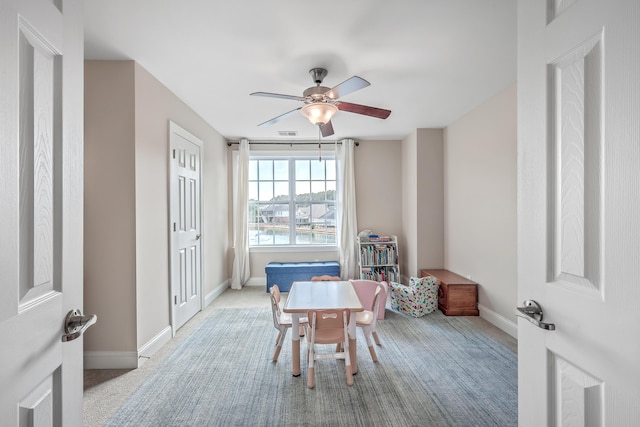 carpeted dining area with ceiling fan