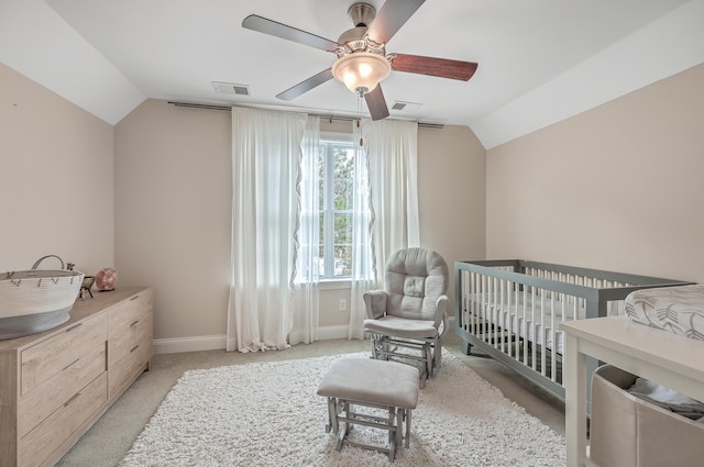 carpeted bedroom featuring vaulted ceiling, ceiling fan, and a crib