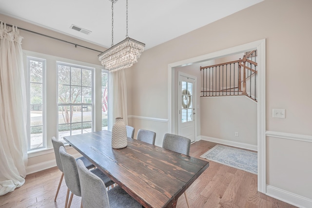 dining area featuring a notable chandelier and light wood-type flooring