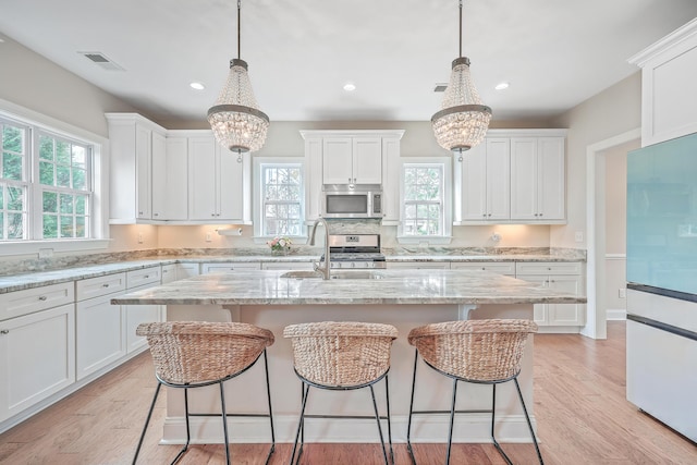 kitchen featuring light hardwood / wood-style floors, white cabinetry, and stainless steel appliances