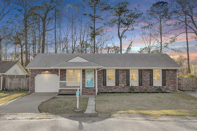 single story home with brick siding, a lawn, an attached garage, and fence