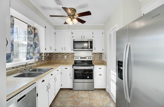 kitchen featuring visible vents, a sink, stainless steel appliances, light countertops, and backsplash