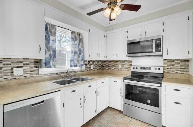 kitchen featuring a sink, white cabinets, light countertops, appliances with stainless steel finishes, and decorative backsplash