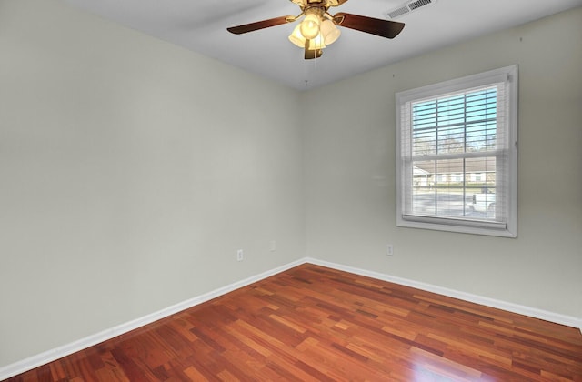 spare room with a ceiling fan, baseboards, visible vents, and wood finished floors