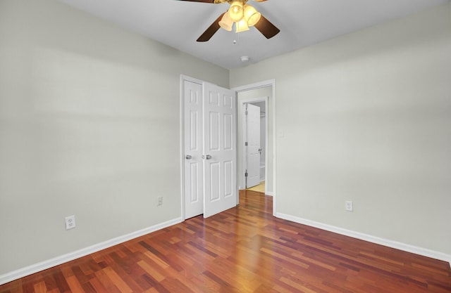 unfurnished bedroom featuring a ceiling fan, a closet, baseboards, and wood finished floors