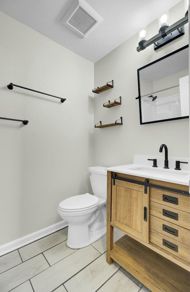 bathroom featuring baseboards, visible vents, vanity, and toilet