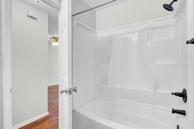 full bathroom featuring  shower combination, baseboards, and wood finished floors