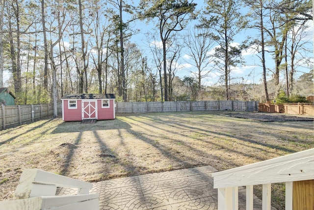 view of yard with an outbuilding, a storage shed, and a fenced backyard