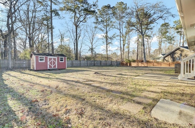 view of yard with an outbuilding, a fenced backyard, and a storage unit