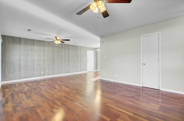 unfurnished room with visible vents, wood finished floors, a ceiling fan, and baseboards