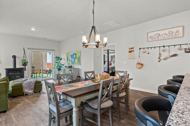 dining space with dark hardwood / wood-style floors and a chandelier