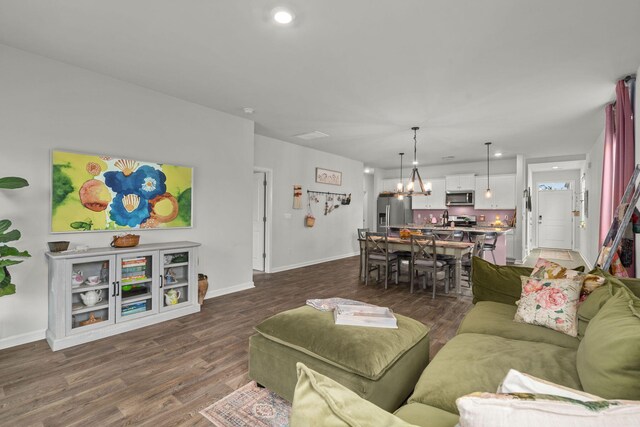 living room featuring dark wood-type flooring and a notable chandelier