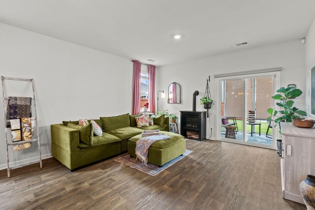 living room featuring a wood stove and wood-type flooring